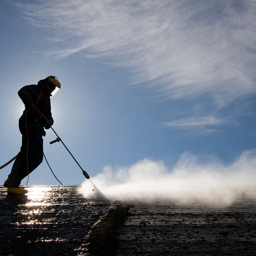 Man holding high performance pressure washer in Denver and Colorado Springs, CO